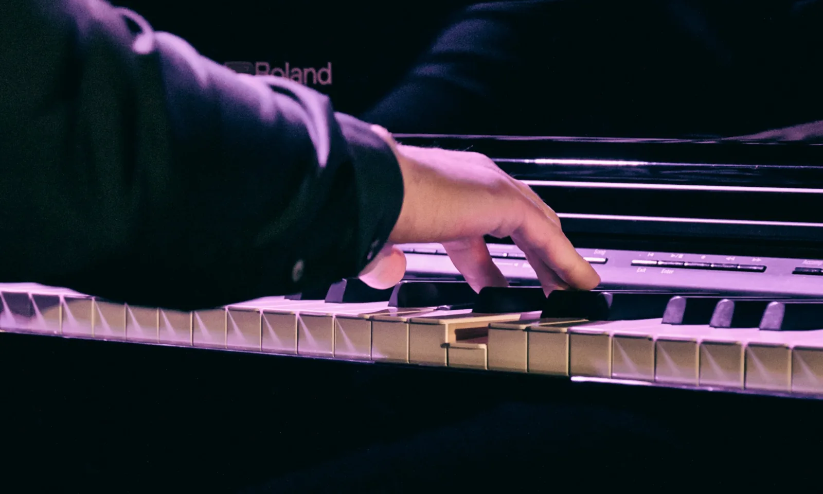 La main droite d'Adel Hakimi sur le clavier, en gros plan.