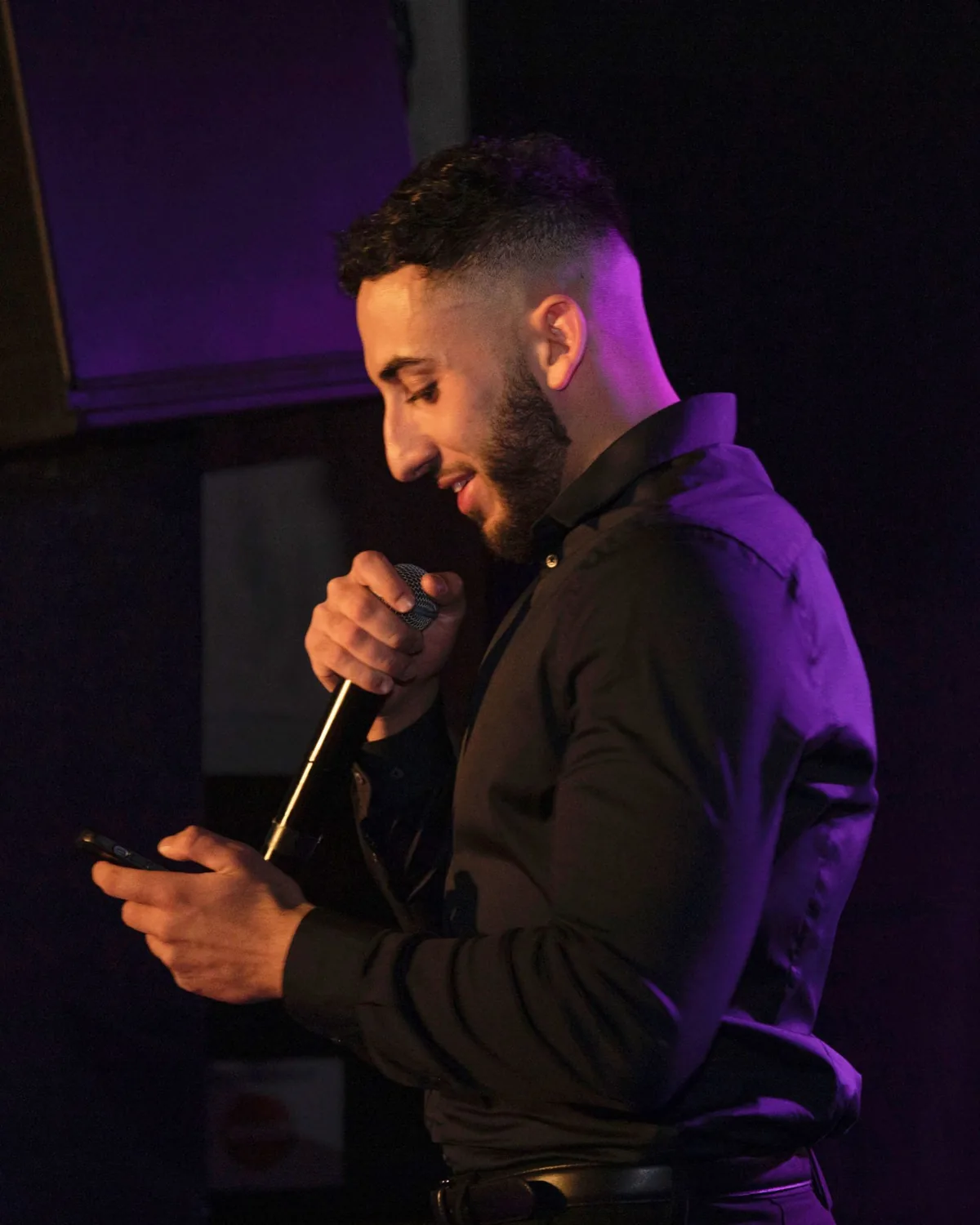 Adel Hakimi, souriant, s'adresse au public au micro.